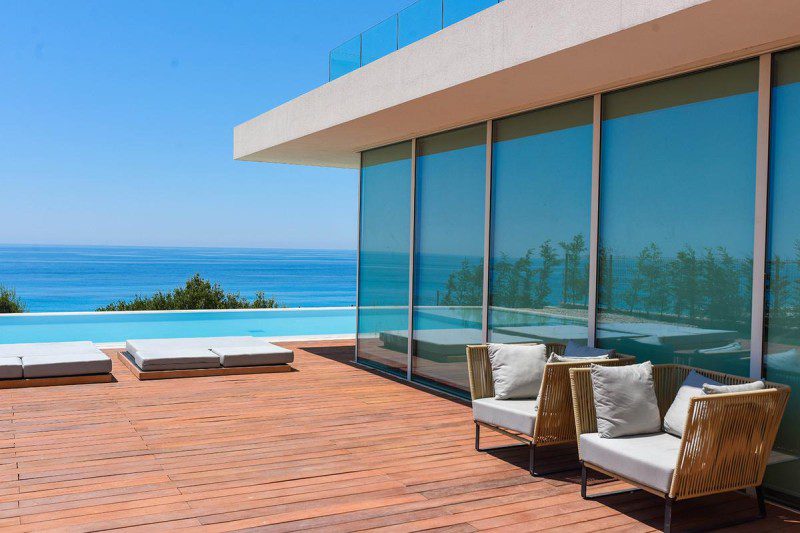 A luxurious villa with an infinity pool overlooking the turquoise sea.